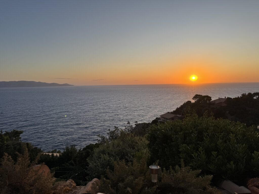 A beautiful sunset over the sea, with a mountanous archepelago in the background.