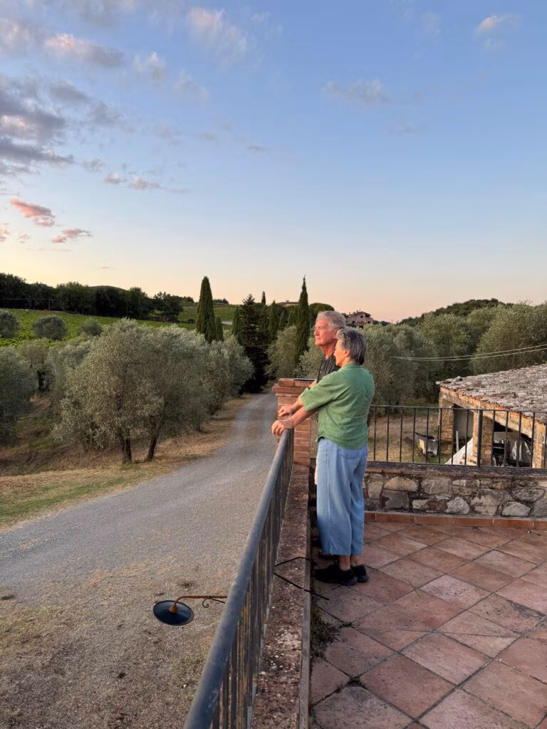 An older couple takes in a sunset in Tuscany.