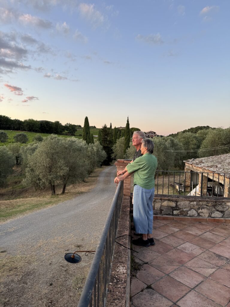 An older couple takes in a sunset in Tuscany.