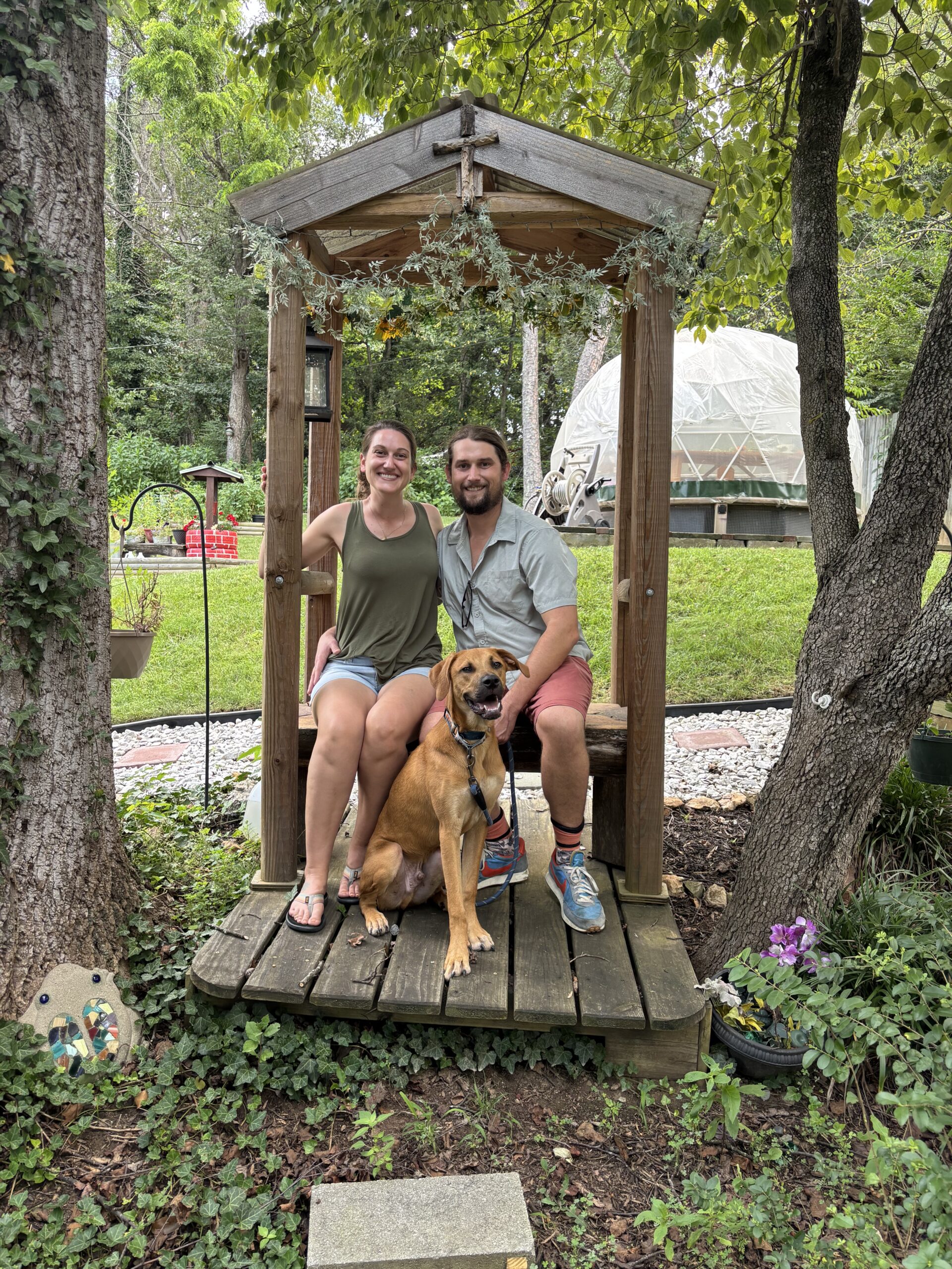 A couple sits with their smiling dog in front of them. This is a photo worth printing.